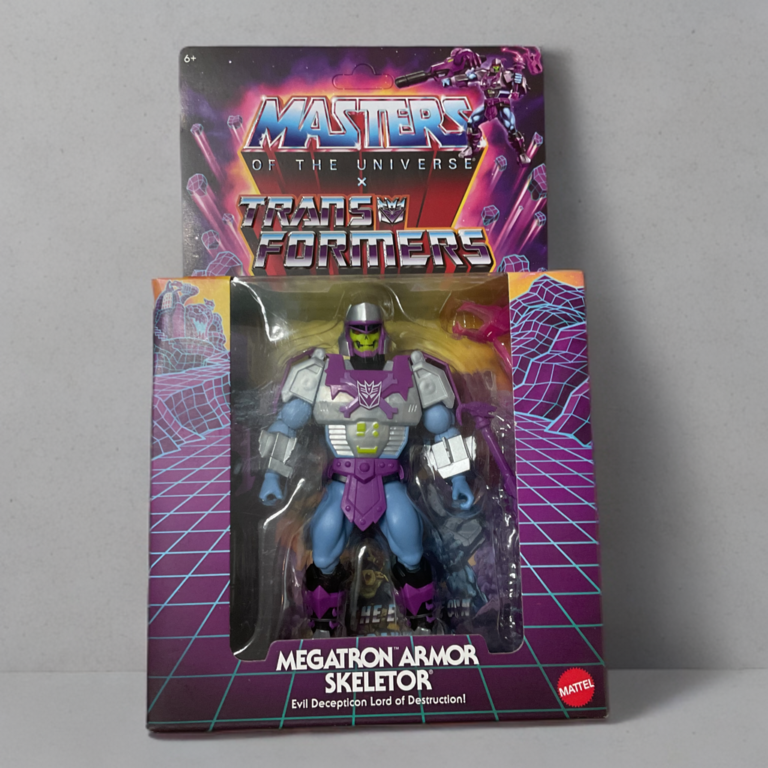 Vista frontal de la caja de coleccionista Masters del Universo Orígenes x Transformers Megatron Armadura Skeletor con ilustraciones dinámicas de los villanos.