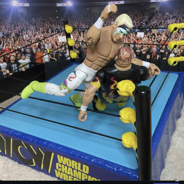Surfer Sting Actionfigur in bunten Neon-Strumpfhosen und bleichblondem Haar, klassischer Stinger-Splash auf Bam Bam Bigelow.