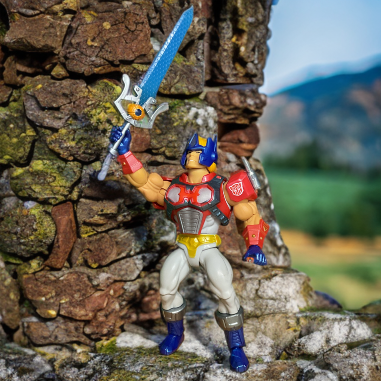 オプティマスプライム アーマー ヒーマン アクションフィギュア マトリックスパワーソードを掲げたフルアーマーポーズ、赤と青のオートボットにインスパイアされた胸部プレートとヘルメットを見せる