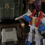 G1 Transformers Bruticus combiner robot towering in battle pose with his creator Starscream standing at his feet.