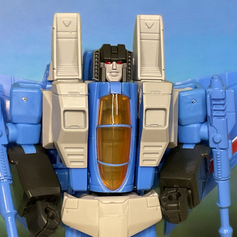 スタジオ・シリーズのサンダー・クラッカー・ロボット・モード頭部のクローズアップ、にやにや笑いの顔と黄色いバイザーの目が特徴。.