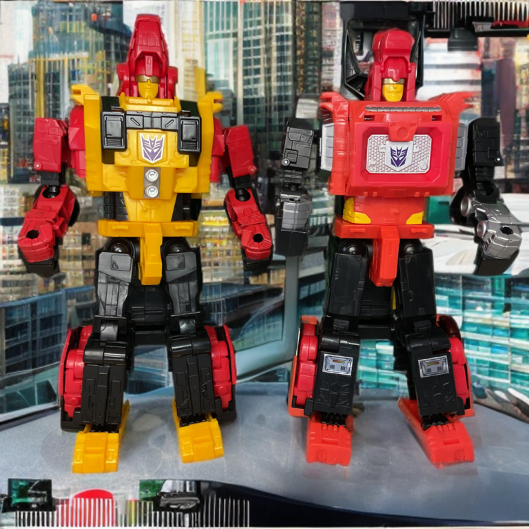 Transformers Power of the Primes Torox und Headstrong in Robotergestalt posieren Seite an Seite vor einem ahnungslosen Stadthintergrund; Torox mit roter Rüstung und großen goldenen Hörnern, Headstrong mit grau-schwarzer Rüstung und markantem Nashornhorn, beide in selbstbewusster Haltung und waffenbereit.