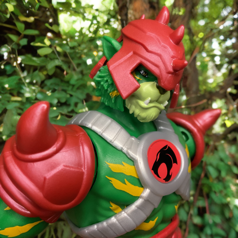 Powerful stance of Battle Cat-Man Origins figure with red armor accents and yellow lightning markings.