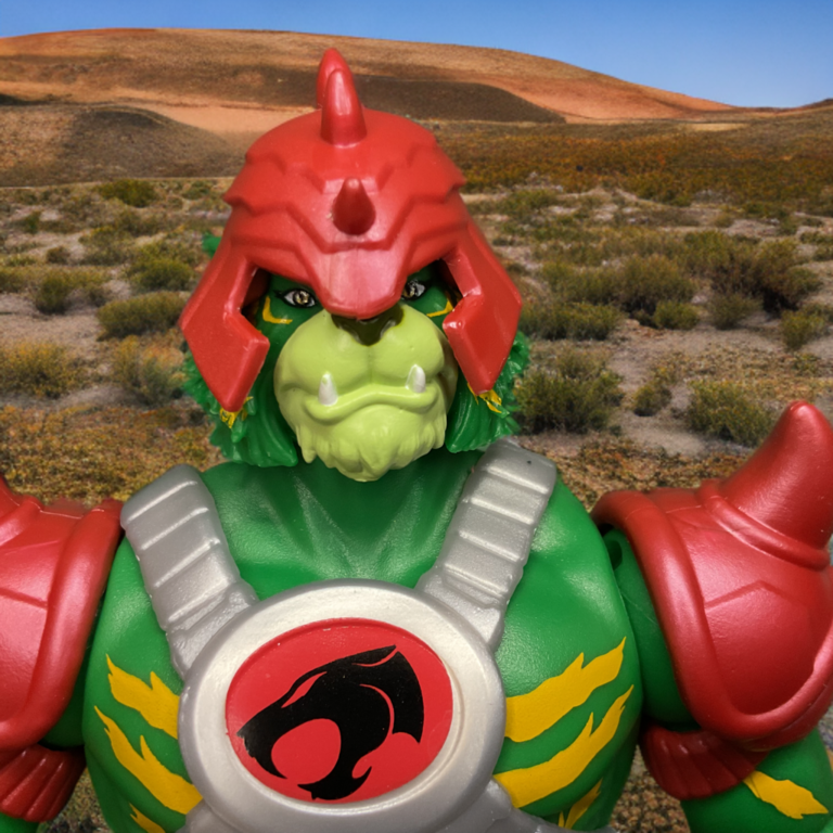 Close-up of Battle Cat-Man Origins figure head with fierce expression, fangs, and red armored helmet.