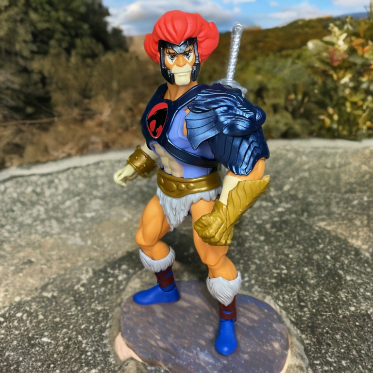 1980s original Thundercats Lion-O figure perched on a large rock outcrop outdoors, hybrid design with confident stance in daylight.
