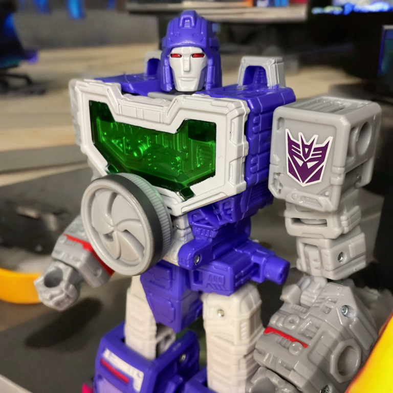 Close-up of Reflector in Dramatic Capture Series with green lens and Decepticon insignia.