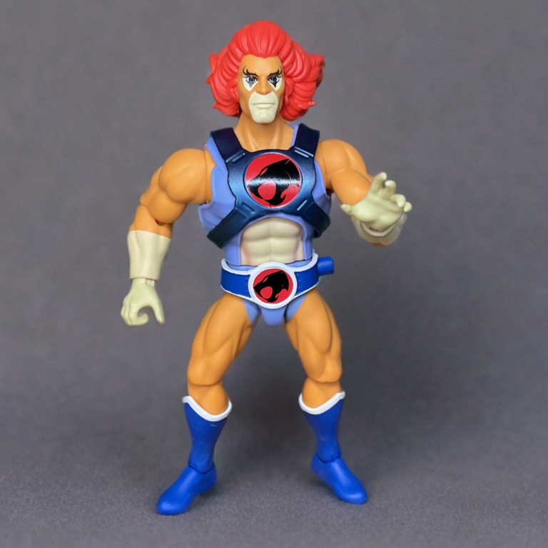 Original look 1980's style Lion-O action figure in classic red mane and blue armor pose, standing isolated against a plain neutral gray or white background for clean product view.