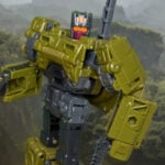 Transformers Age of the Primes Combaticon Brawl Voyager Class figure in robot mode standing on a smoky battlefield.