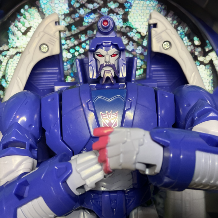 Studio Series Scourge Voyager Class figure in robot mode, accurate G1 coloring and detailing on a dynamic background.