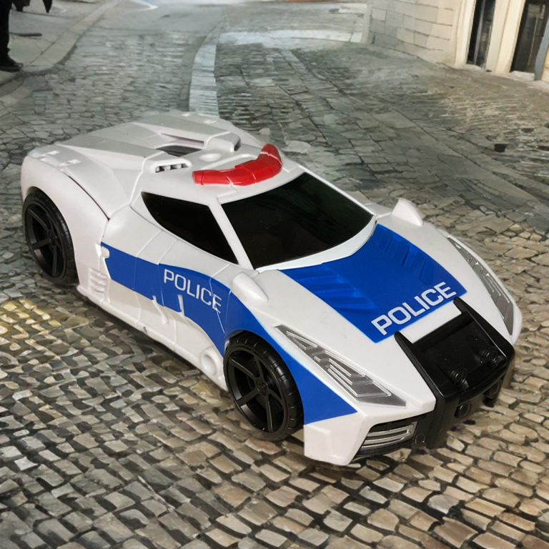 A white police interceptor car toy with "Police" decals and sirens.
