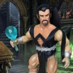 Eine Hochkantaufnahme der alten Deimos-Actionfigur mit seinem charakteristischen dunklen Stoffumhang.