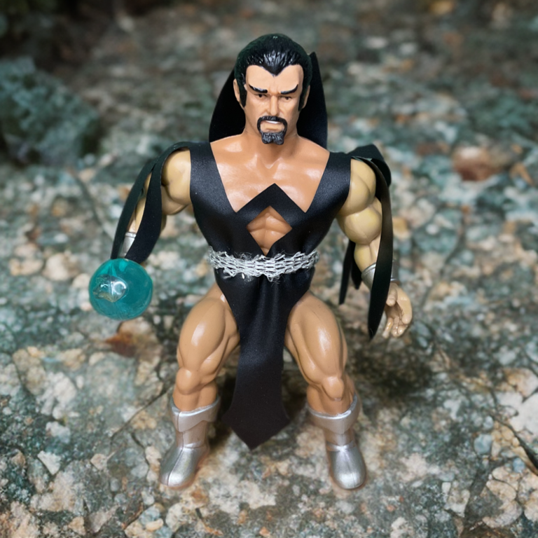 The Remco Deimos figure standing victoriously on a rock, silhouetted against a dark orange background.