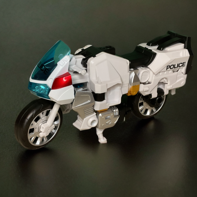 A white police touring motorcycle toy with clear windshield and siren details.