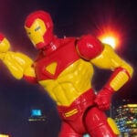 A figura de ação Marvel Legends Retro Deluxe Iron Man posa dinamicamente contra um fundo limpo, exibindo a Armadura Modular vermelha e dourada da série animada de 1994 com reator de arco quadrado, acessório de canhão de plasma acoplado e mãos intercambiáveis. Colecionável nostálgico dos anos 90 da Fantasy Action Figures.