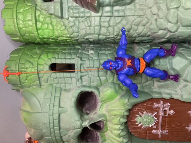 Webstor figure using his grappling hook to hang from Castle Grayskull.