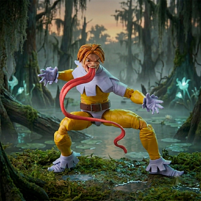 A Toad action figure positioned in a dark, atmospheric swamp at dusk. The figure is wearing a yellow and lavender jester-like outfit with ruffled cuffs. His mouth is wide open, exposing a long, stylized pink tongue that loops through the air, while the background features misty waters, lily pads, and eerie glowing flora.